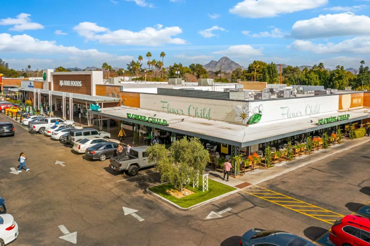 Flower Child restaurant at corner of shopping center with patio and parking lot.