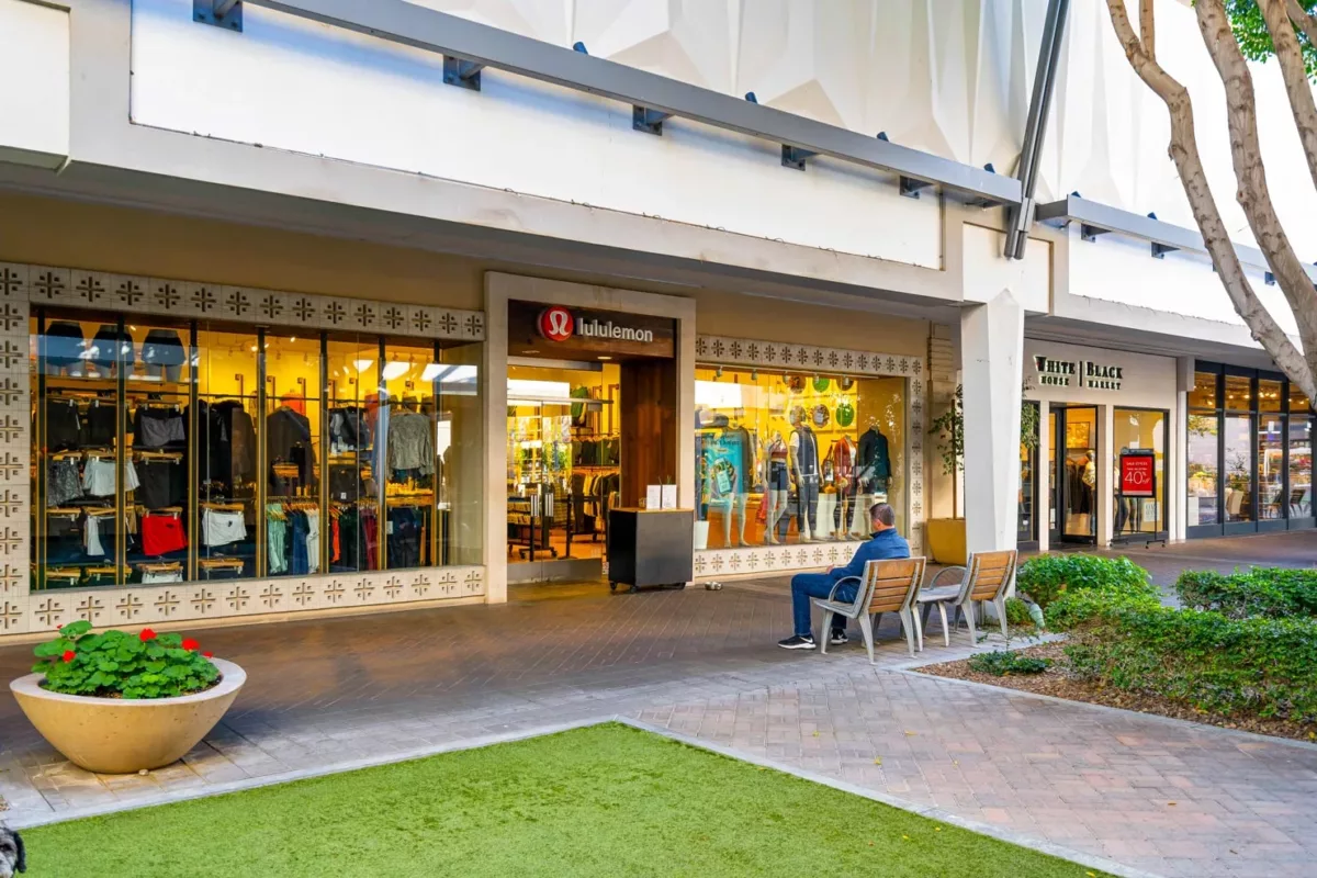 Outdoor shopping walkway with Lululemon storefront, benches, and planters.