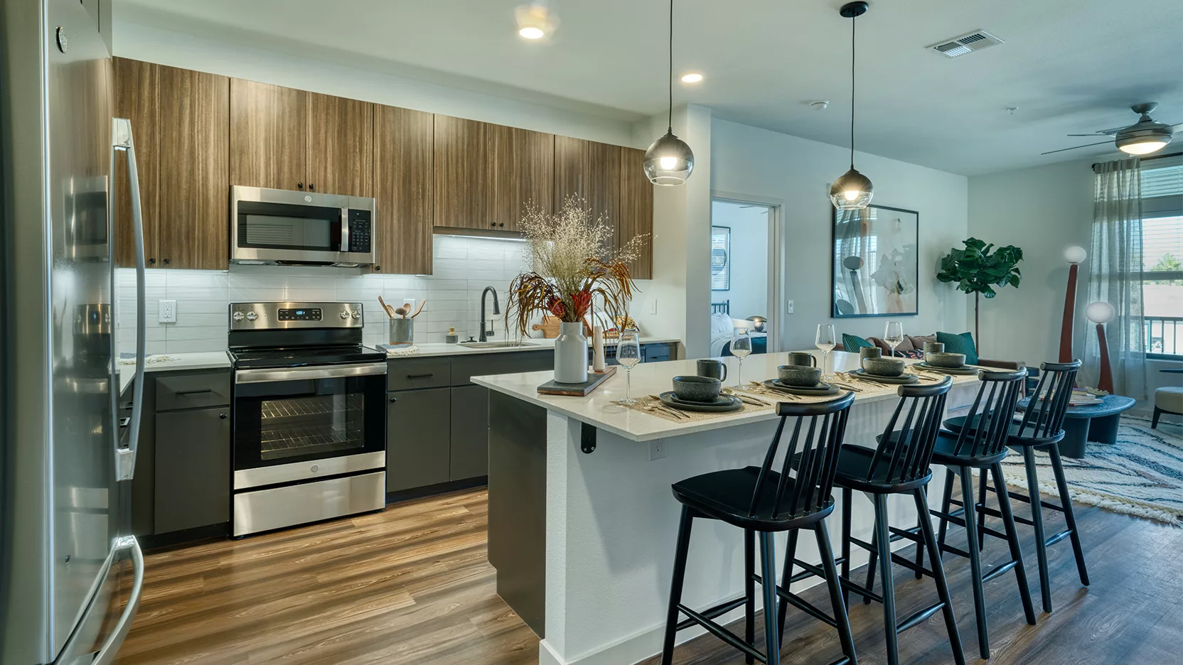 Callia kitchen island with barstools, wood cabinets and wood floors